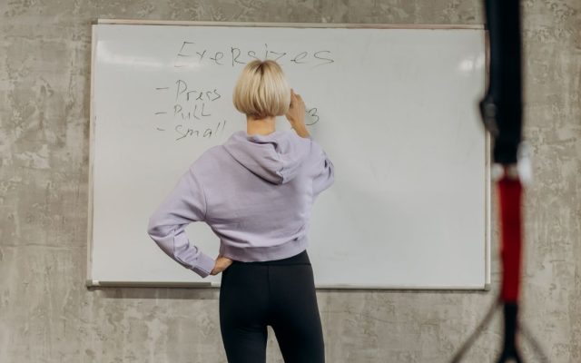 Person planning a weekly workout routine at the gym