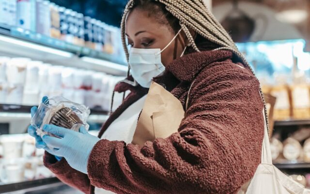 Woman reading a food label in a supermarket to check for added sugar