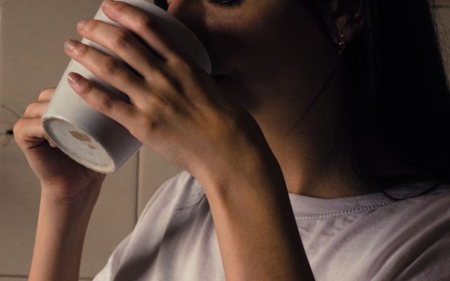Woman holding a warm cup of coffee in the morning light