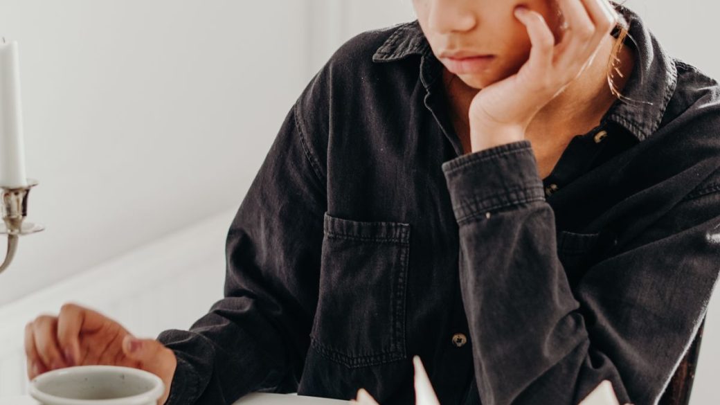 Woman sitting quietly and reflecting, looking calm and thoughtful