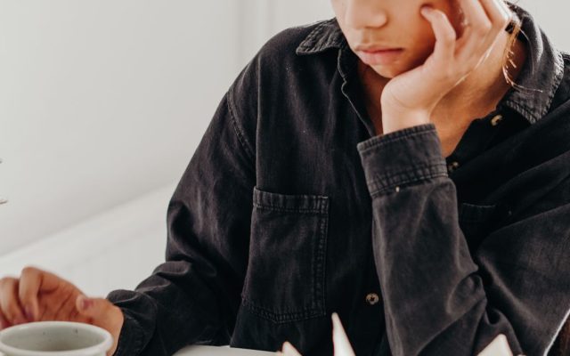 Woman sitting quietly and reflecting, looking calm and thoughtful