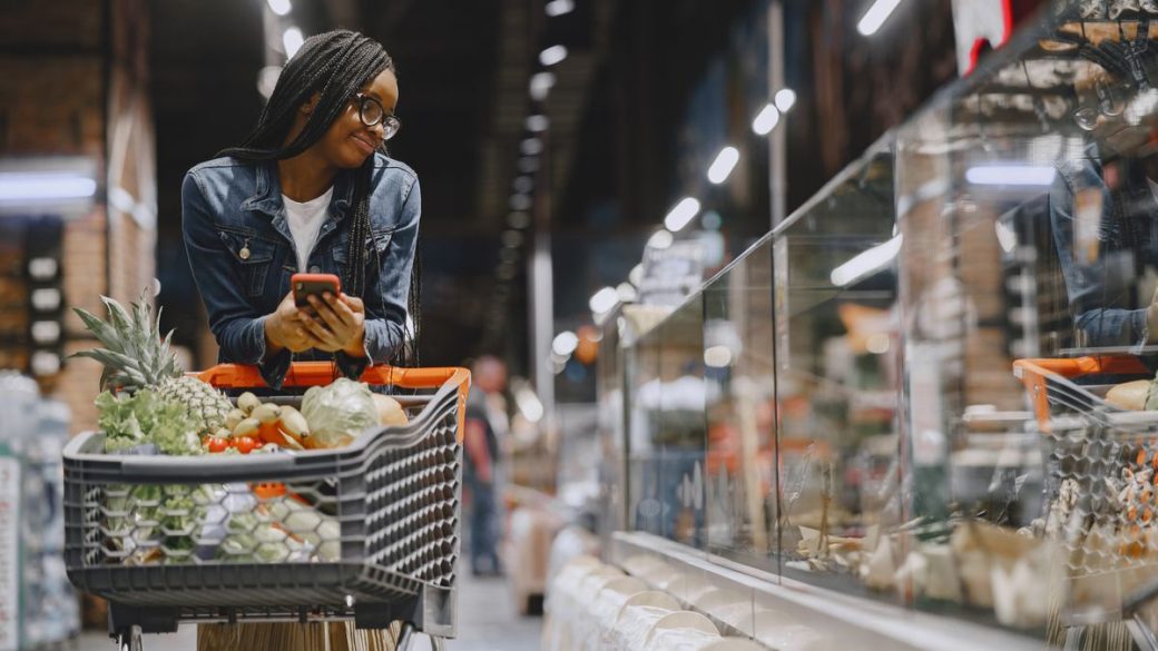 Woman reading a food package label while grocery shopping