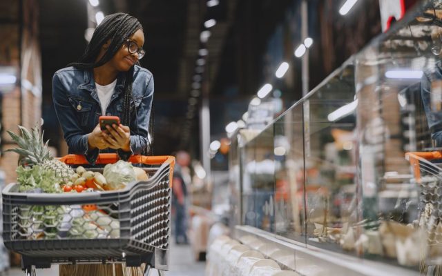 Woman reading a food package label while grocery shopping