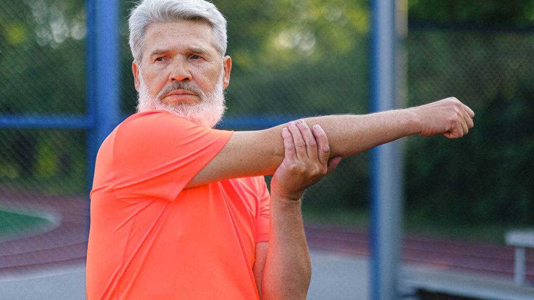 Active mature man stretching outdoors before exercise