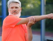 Active mature man stretching outdoors before exercise