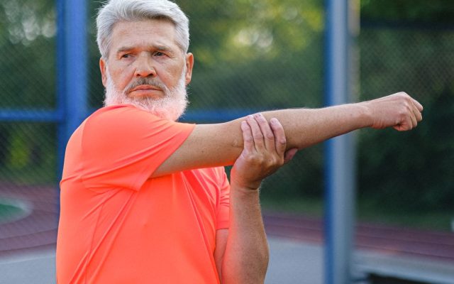 Active mature man stretching outdoors before exercise