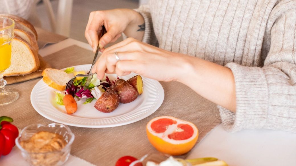 Woman enjoying a fresh colorful vegetable salad