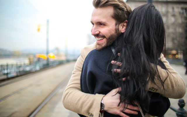 Happy couple embracing and laughing together outdoors