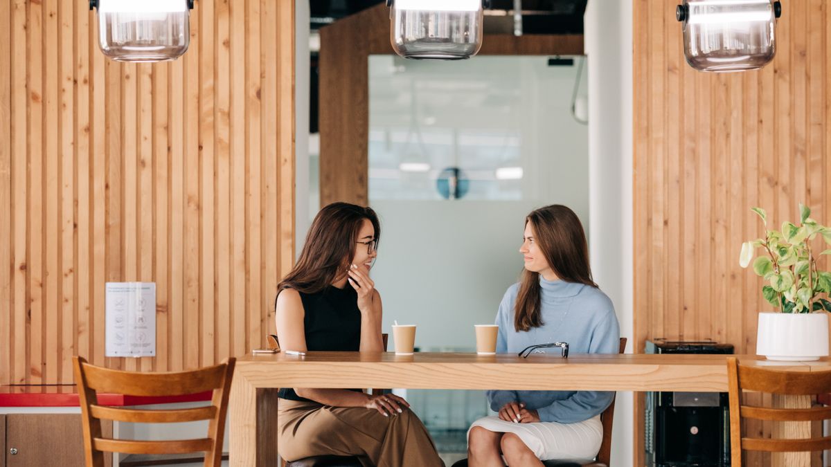 Two friends talking over coffee, building meaningful connection
