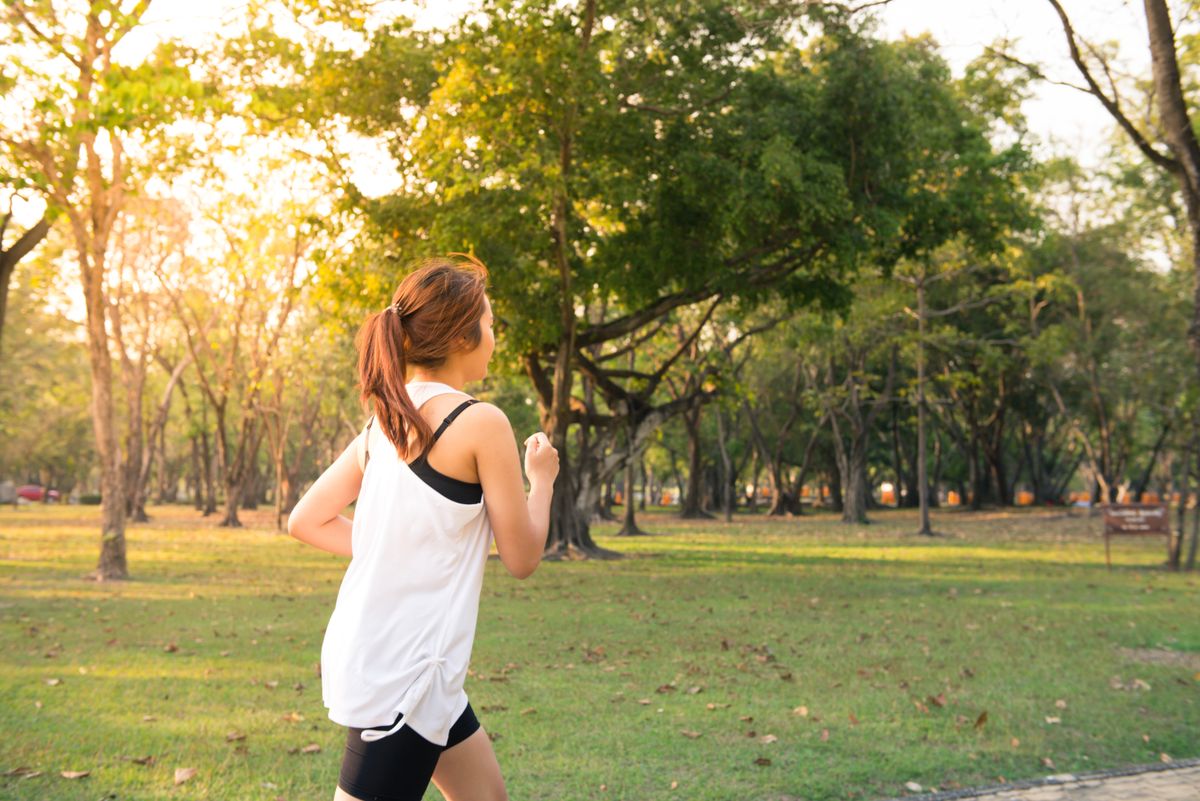 Woman walking at golden hour on an outdoor path
