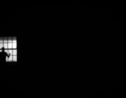 Person looking pensively out a window, coping with loneliness