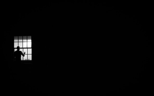 Person looking pensively out a window, coping with loneliness