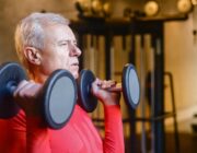 Fit older man lifting dumbbells to support men's health after 50