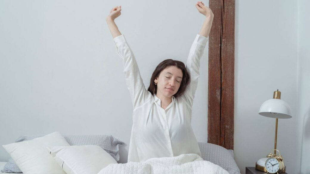 Tired woman waking up in bed in the morning, still feeling fatigued