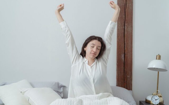 Tired woman waking up in bed in the morning, still feeling fatigued