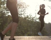 Two women walking briskly for exercise in a sunny park