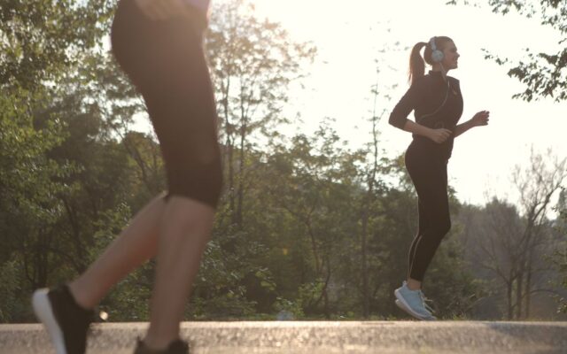 Two women walking briskly for exercise in a sunny park