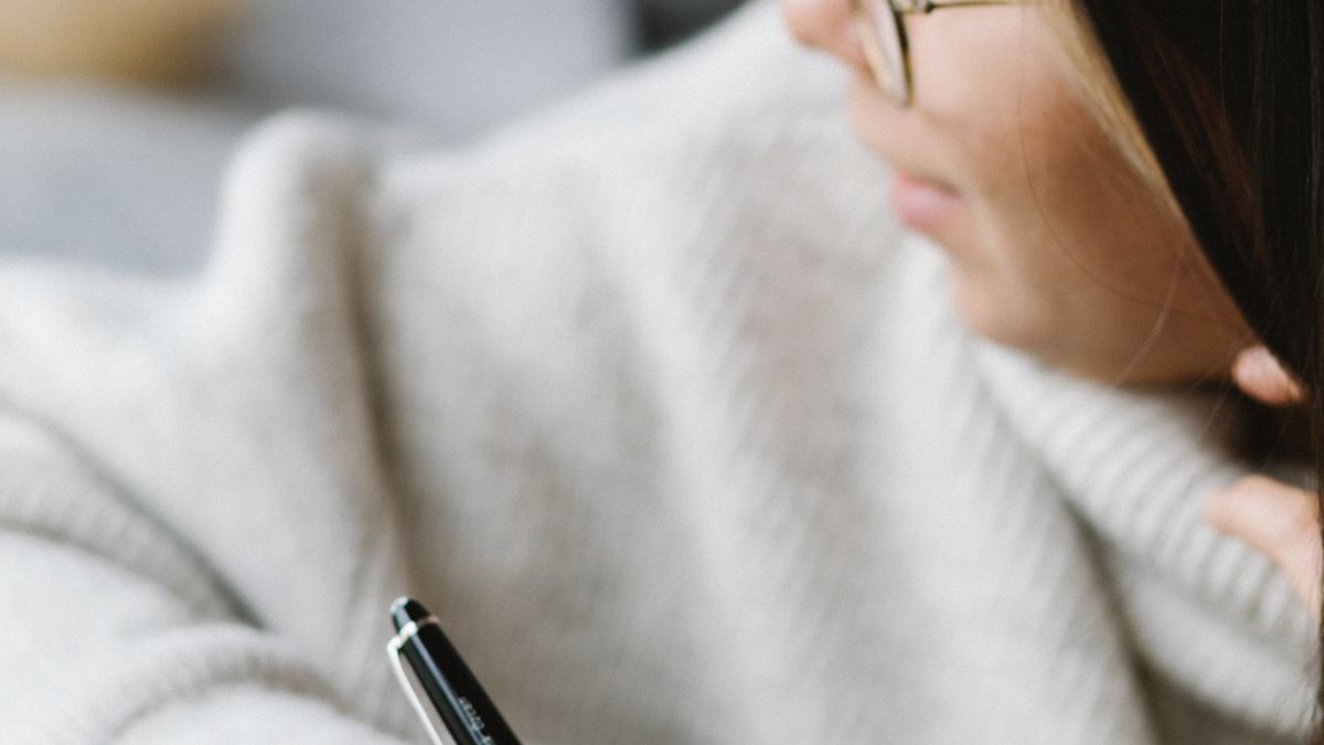 Woman writing a simple plan in a notebook to reduce decision fatigue