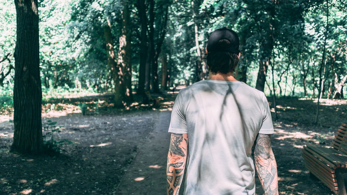 Man walking at the park as part of reaching his daily step count