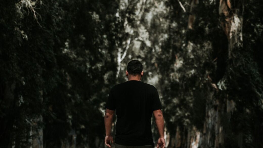 Man walking along a tree-lined park path getting his daily steps