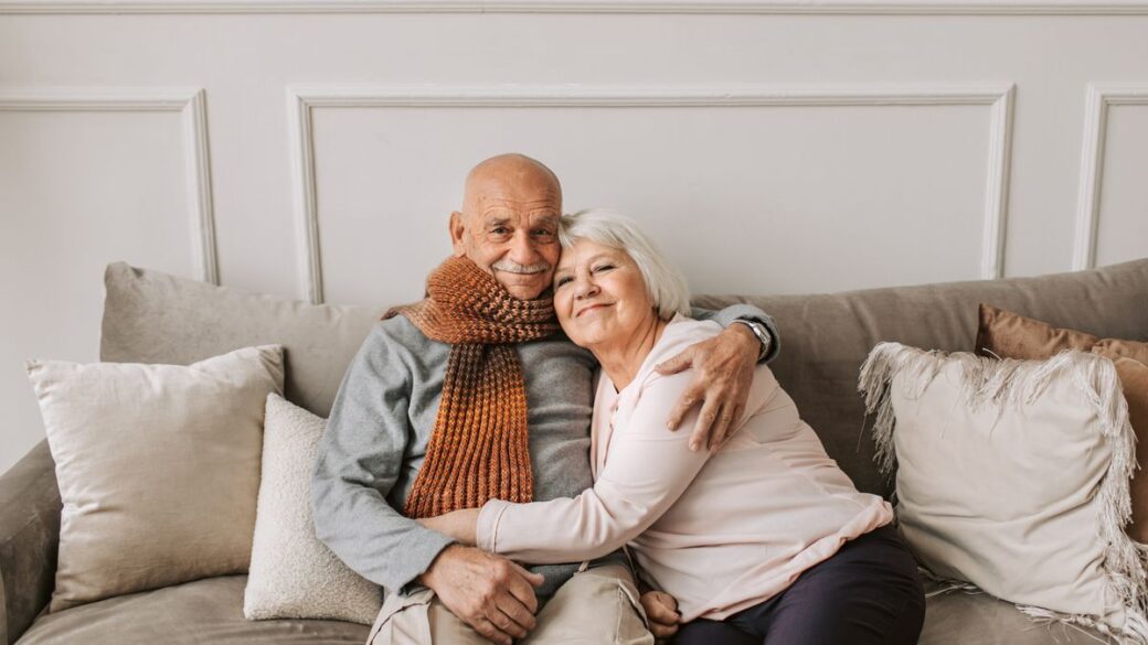 Affectionate mature couple sitting close together on a couch