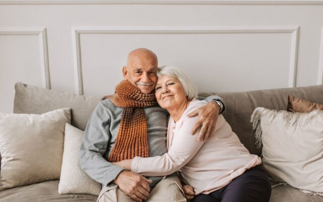 Affectionate mature couple sitting close together on a couch