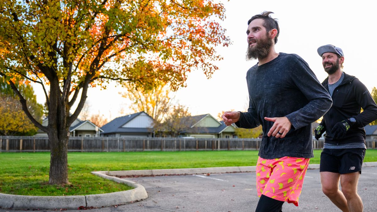 Two men on a morning jog in a park, an example of a consistent workout time