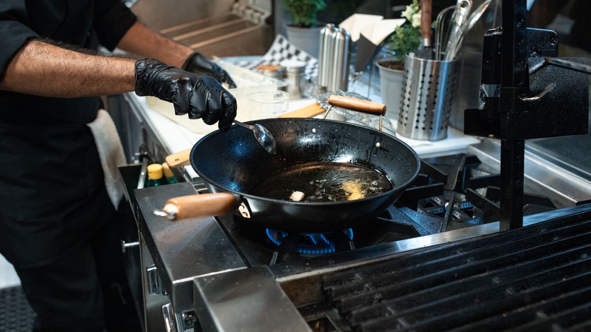 Person cooking fish in a pan, an easy way to add more omega-3 to weekly meals