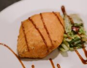 Grilled salmon fillet on a plate, one of the richest food sources of omega-3 fatty acids