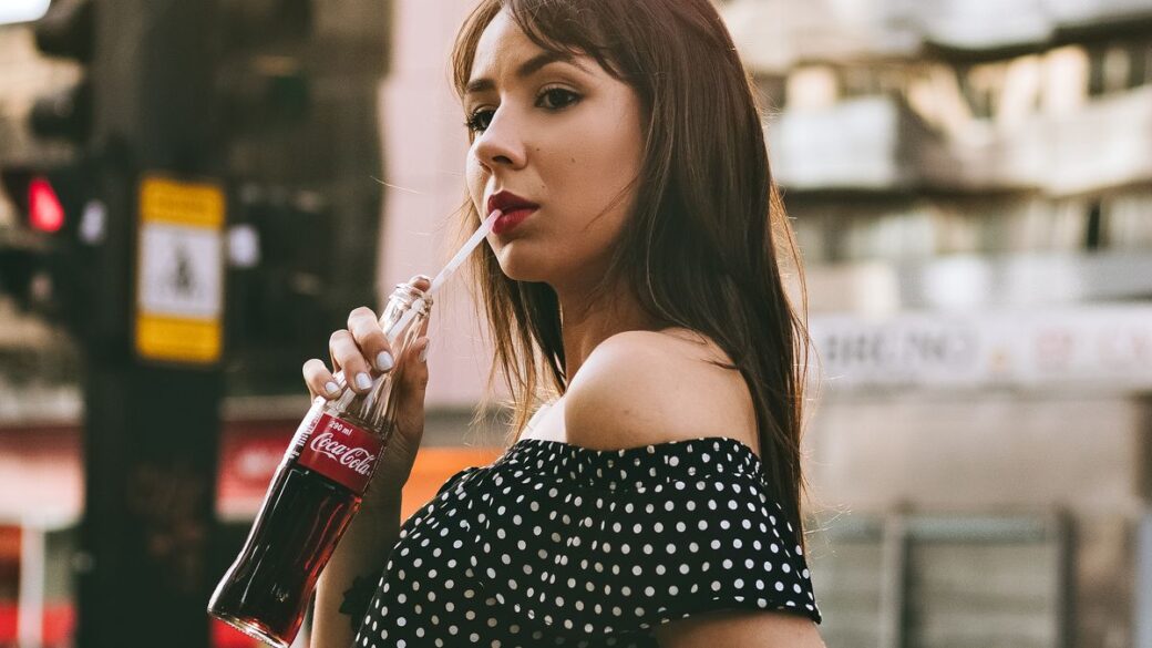 Woman drinking a sugary soft drink on a city street