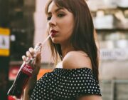 Woman drinking a sugary soft drink on a city street