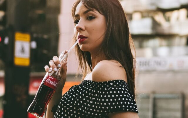 Woman drinking a sugary soft drink on a city street