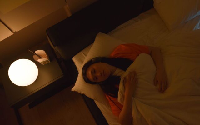 Woman lying awake in bed at night, unable to sleep because of stress
