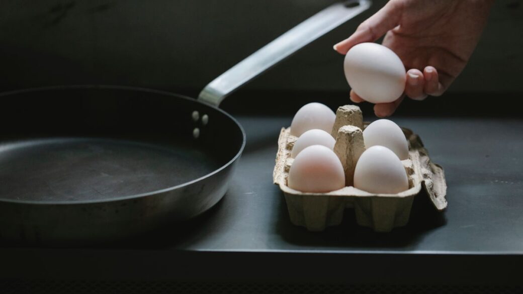 Woman taking an egg from a carton in her kitchen, a good source of vitamin B12