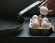 Woman taking an egg from a carton in her kitchen, a good source of vitamin B12
