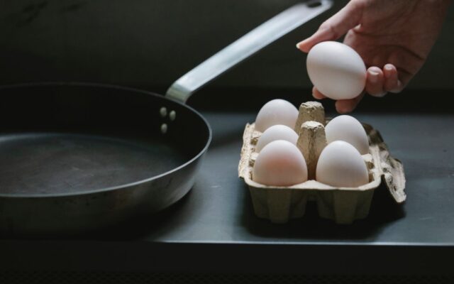Woman taking an egg from a carton in her kitchen, a good source of vitamin B12