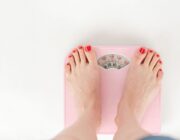 Woman standing on a bathroom scale, illustrating set point theory and weight regulation