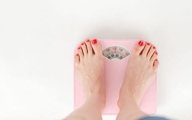 Woman standing on a bathroom scale, illustrating set point theory and weight regulation