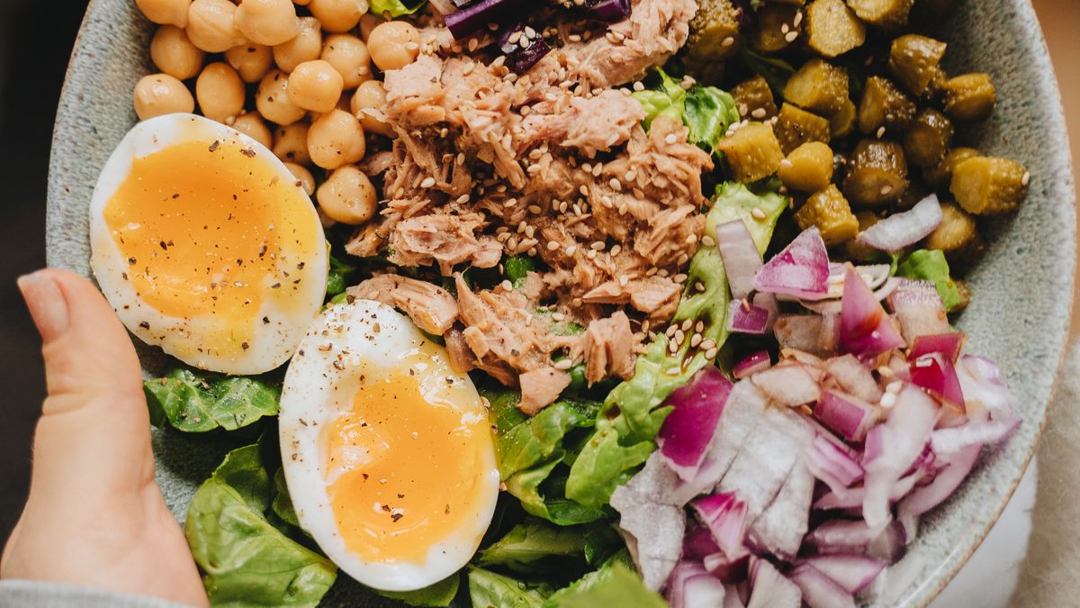 Person holding a bowl with a healthy portioned meal to manage portion sizes