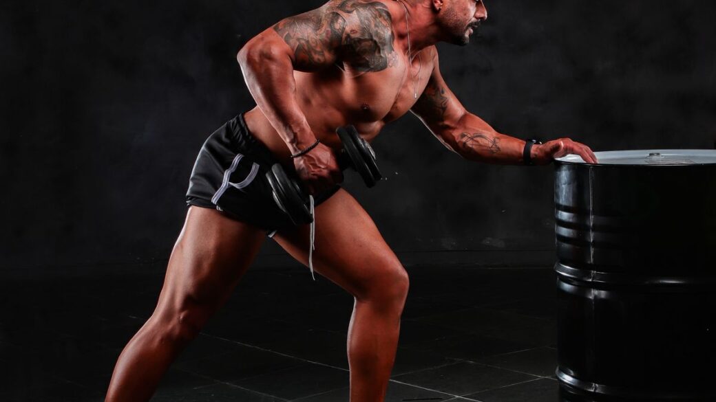 Man lifting a dumbbell with controlled form in a gym