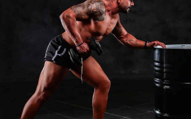 Man lifting a dumbbell with controlled form in a gym