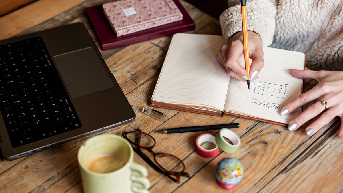 Woman writing notes in a planner to close out the workweek and ease Sunday anxiety
