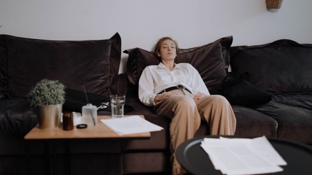 Woman sitting on a couch on Sunday evening feeling the Sunday scaries before the workweek