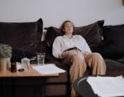 Woman sitting on a couch on Sunday evening feeling the Sunday scaries before the workweek