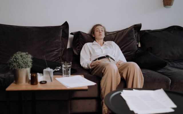 Woman sitting on a couch on Sunday evening feeling the Sunday scaries before the workweek