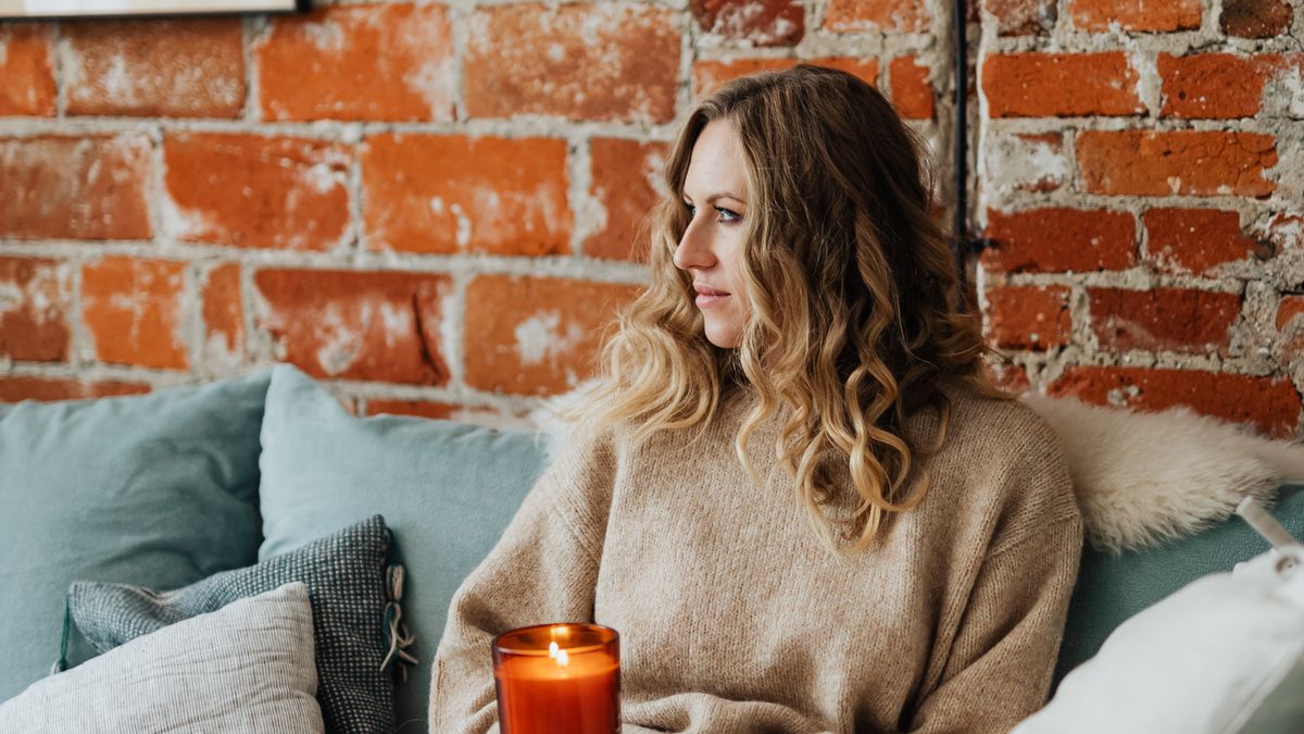 Woman relaxing on a sofa wrapped in a weighted blanket