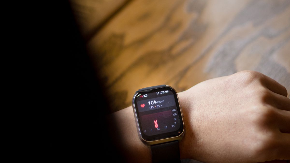 Runner checking heart rate for zone 2 cardio on a smartwatch